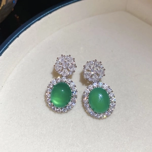 Gros plan de boucles d'oreilles en argent avec calcédoine verte ovale et fleurs en zircon