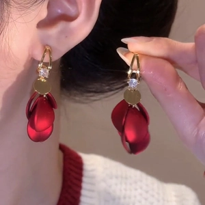 Close-up of red flower petal tassel earrings with gold alloy and zircon details