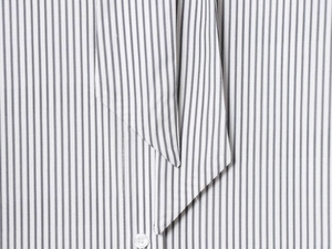 Détail d'un chemisier en coton blanc à rayures noires, décolleté et boutons précis