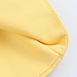 Detail shot of yellow twill fabric dress showing high-quality texture and precise stitching
