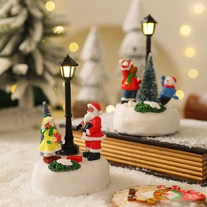 Dettaglio di una scena natalizia in miniatura con Babbo Natale e lampione a LED illuminato