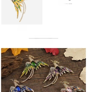 Detailed close-up of yellow phoenix brooch with colorful crystals on wood background