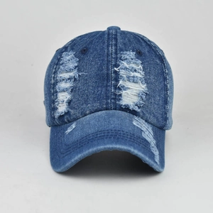 Detailed close-up of distressed denim baseball cap with vintage frayed edges