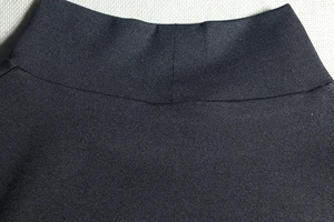 Close-up of the stand-up collar and high-density knitted texture on a black slim dress