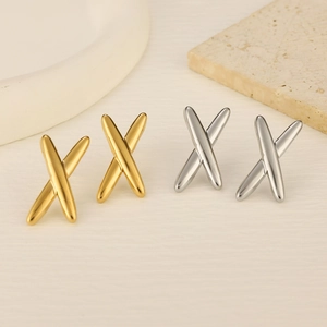 Detail of geometric X-shaped stainless steel stud earrings in gold and silver finish