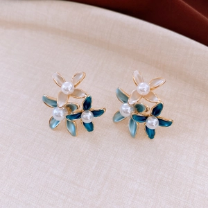 Macro shot of 18K gold plated pearl flower earrings with blue and white petals