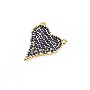 Macro shot of heart-shaped gold pendant with micro-pave blue cubic zirconia stones