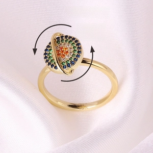 Close-up of golden rotating planet ring with colorful gems on white silk, weight 2.6g