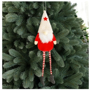 Close-up of a faceless gnome ornament with red hat and long legs hanging on a Christmas tree