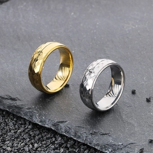 Macro view of gold and silver hammered texture rings on dark stone surface