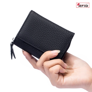 Black pebbled leather tri-fold mini RFID wallet for women shown in hand on white background