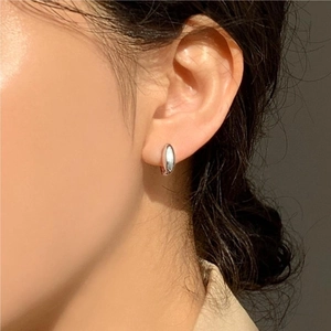Close-up of minimalist 925 sterling silver hoop earrings worn by a female model