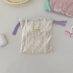 Detail of cream velvet drawstring pouch with lace trim and purple ribbon ties