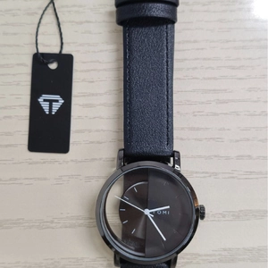 Detailed top view of the TOMI quartz watch with leather strap on a wooden desk