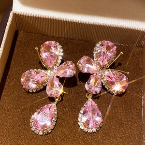 Close-up of vintage pink crystal butterfly earrings in a brown velvet jewelry box