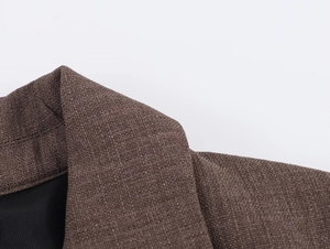 Détail du tissu texturé marron et de la couture du col d'un blazer décontracté
