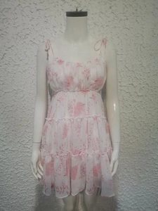 Detail of white floral sundress showing red print and layered chiffon tiered hem