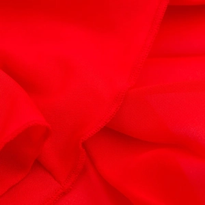 Détail macro du tissu rouge de la robe midi et des finitions de couture surjetées