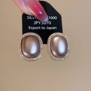 Detailed macro view of vintage gold-plated oval earrings with champagne zircon accents