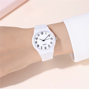 Close-up of minimalist white quartz watch with silicone strap on a person's wrist