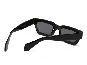 Detail view of black rectangular sunglasses featuring thick glossy frames and dark grey lenses
