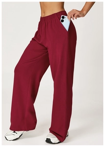 Detail of deep red high-waist joggers showing deep side pockets and knit fabric texture