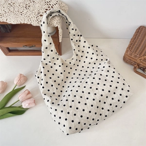 Polka dot canvas tote bag shown with tulips and vintage wooden decor in a lifestyle setting