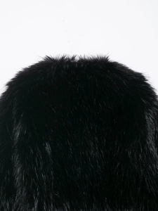 Close-up detail of luxurious black faux fur texture on a cropped fashion jacket