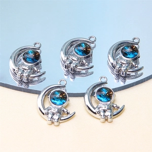 Macro detail of silver astronaut moon charms with blue starry sky dome for DIY jewelry