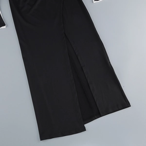 Detail of elegant black dress showing a high slit cut and premium knit fabric texture
