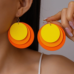 Geometric round wood tiered earrings with yellow and orange gradient circles on model