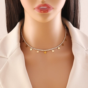 Collana con ciondoli a stella e catena di strass indossata su un blazer beige