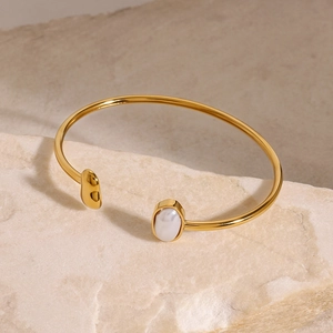 Polished gold open bangle with pearl inlay on natural stone base for elegant women