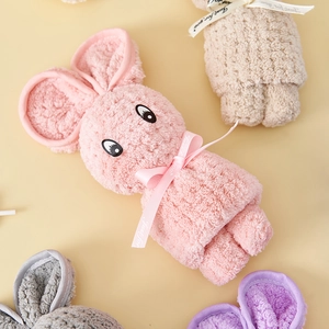 Close-up of assorted coral fleece towels folded in cute bunny shapes with ribbons