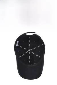 Detail of black baseball cap interior showing logo tape, wash label, and metal buckle