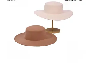 Detail view of two minimalist flat top wide brim wool felt hats in beige and camel colors