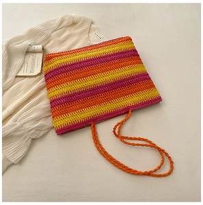 Detail of colorful rainbow striped straw tote bag with twisted rope shoulder strap