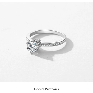 Macro shot of silver crown ring with a round center stone and six-prong setting