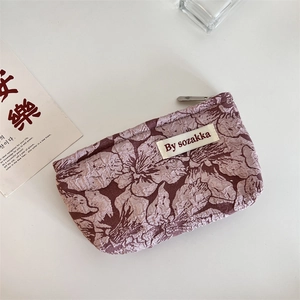 Macro detail of vintage rose floral jacquard texture and woven label on makeup bag