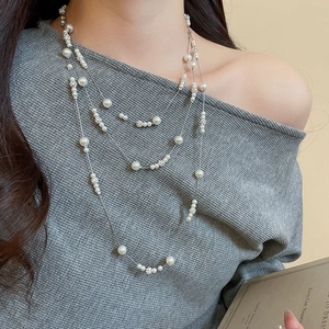 Detailed view of layered pearl necklace with diamond spacers and elegant silver finish