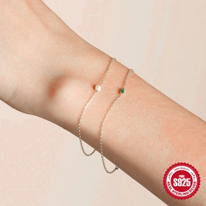 Close-up of S925 silver chain bracelet featuring a green gemstone and white pearl detail