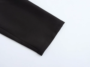 Close-up of black trench coat sleeve cuff showing high-quality stitching and fabric texture