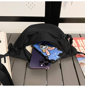 Detail view of the black canvas chest bag showing large capacity for two smartphones