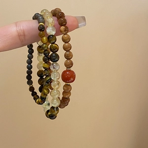 Detailed shot of Tiger Eye and Citrine beaded bracelets with high-quality natural stone texture