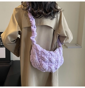 Detail of purple quilted cloud bag with pleated strap and soft ruched fabric texture