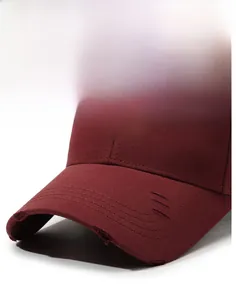 Macro detail of the distressed brim and embroidery on this burgundy cotton baseball cap