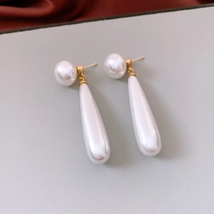 Macro view of gold-tone teardrop pearl earring with elegant sleek design details