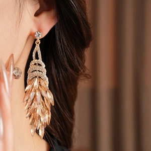 Détail de boucles d'oreilles vintage à pampilles avec strass champagne sur un mannequin