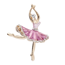 Close-up of golden ballet dancer brooch with pink enamel skirt and crystal accents