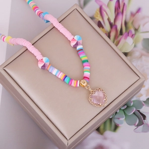 Close-up of Bohemian multicolored beaded necklace with a pink heart pendant on jewelry box